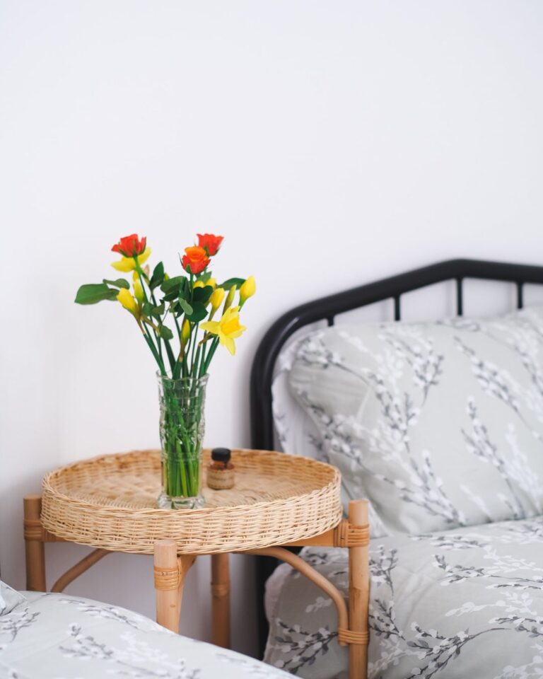 Bedroom at Daybreak House with flowers on a rattan side table